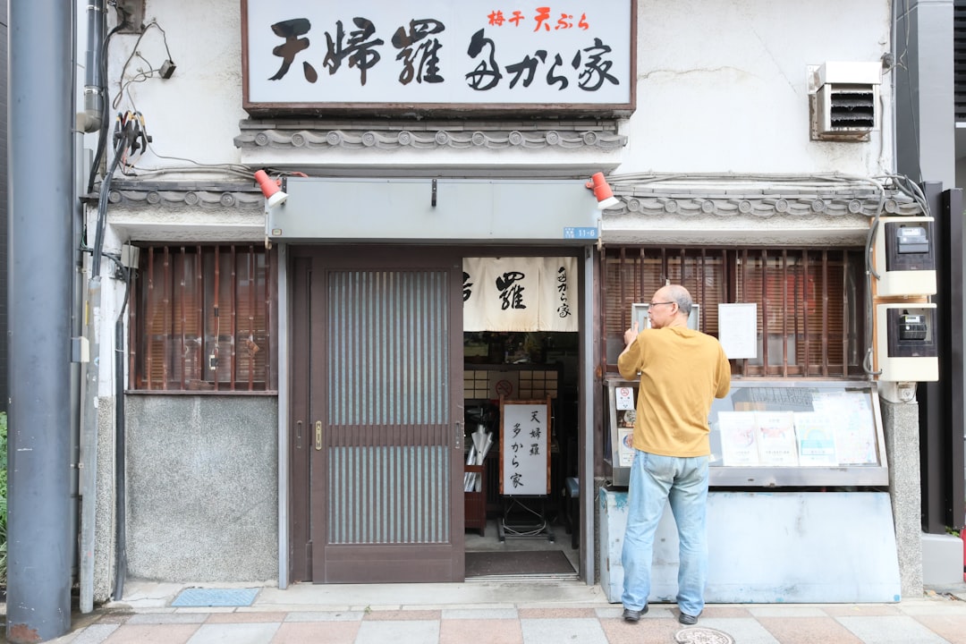 Man looking at a sign outside a japanese restaurant